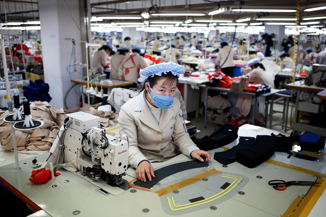 Женщина работает на заводе южнокорейской компании в промышленной зоне Кэсона. девушки, профессия, северная корея