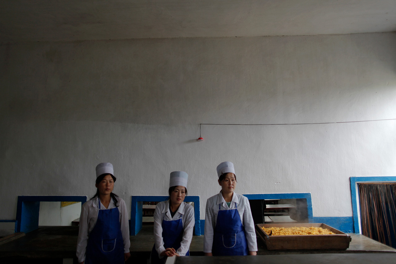 Северокорейские женщины стоят на раздаче кукурузной каши, приготовленной для детей-сирот в провинции Северный Хванхэ. девушки, профессия, северная корея