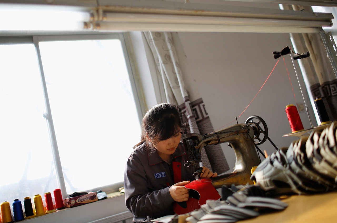 Северокорейская девушка работает на обувной фабрике в деревне Дандон. девушки, профессия, северная корея
