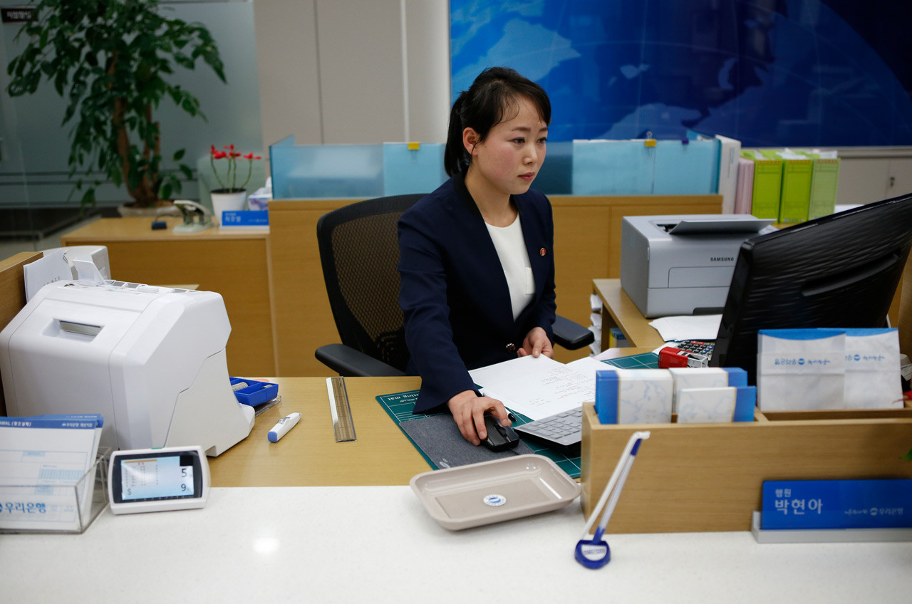 Северокорейская сотрудница работает в банке в промышленной зоне Кэсона. девушки, профессия, северная корея