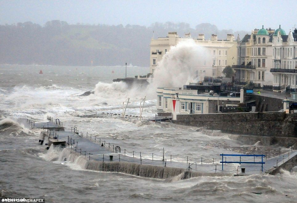 Pounded: A harbour and its waterside restaurant are battered by heavy seas yesterday, leaving debris strewn across the sea front