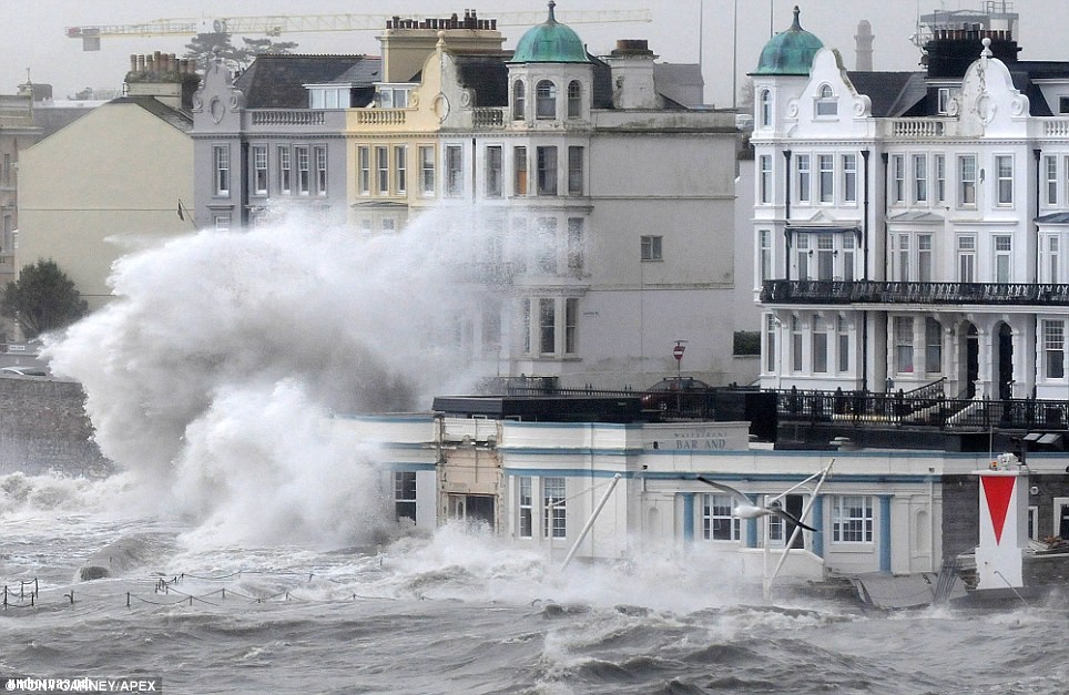 Rising water: A waterside bar is pounded by the waves in Plymouth as the south-west bears the brunt of the Atlantic storm that first hit overnight