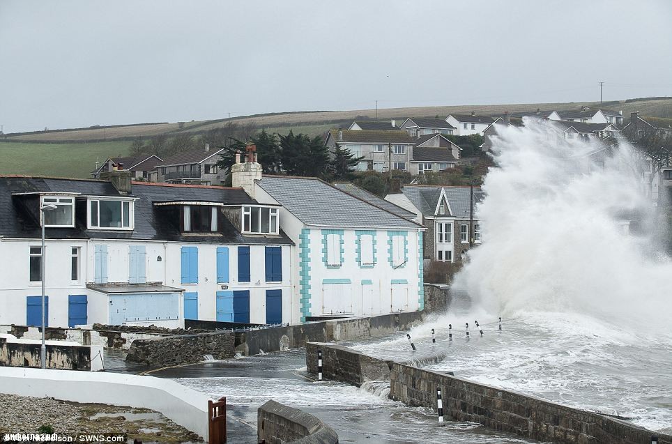 Spray: Waves crash into boarded up houses at Portmellon, Cornwall