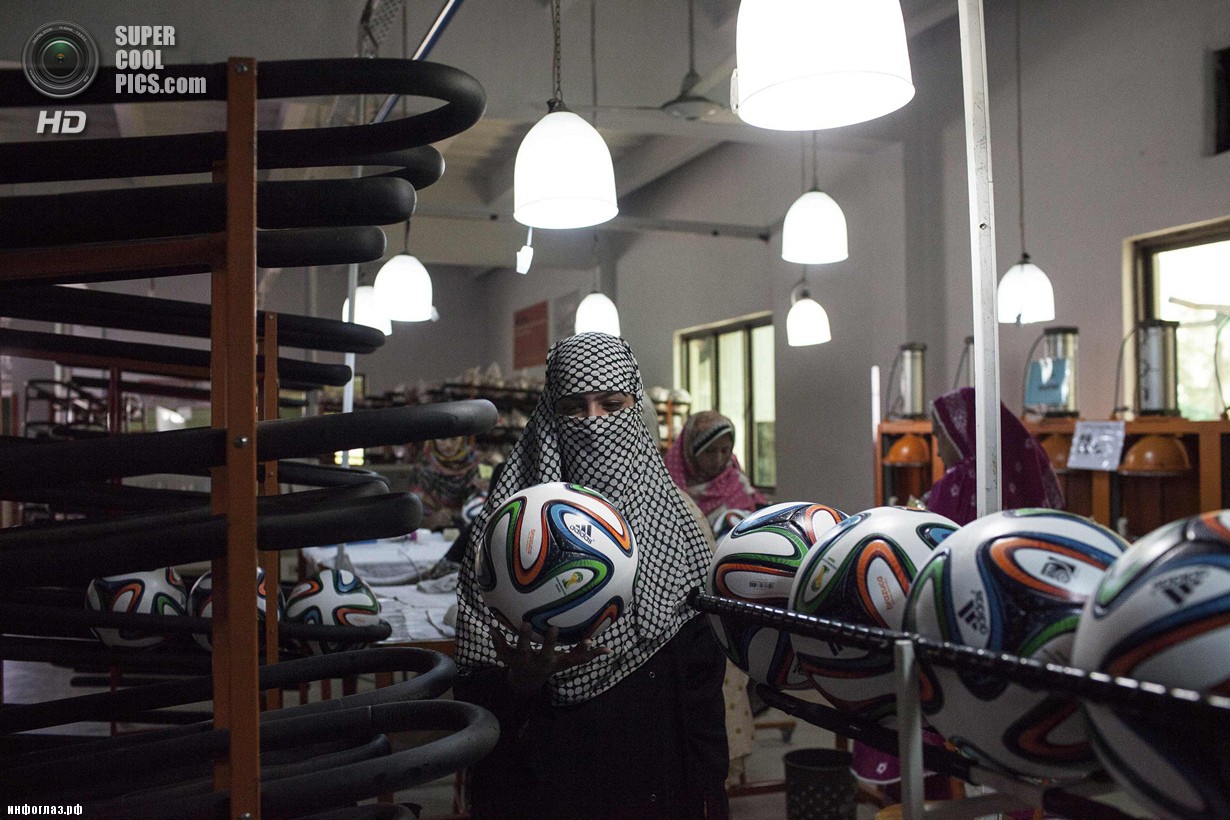 Пакистан. Сиялкот, Пенджаб. 16 мая. Работница фабрики по производству футбольных мячей проверяет форму продукции. (REUTERS/Sara Farid)