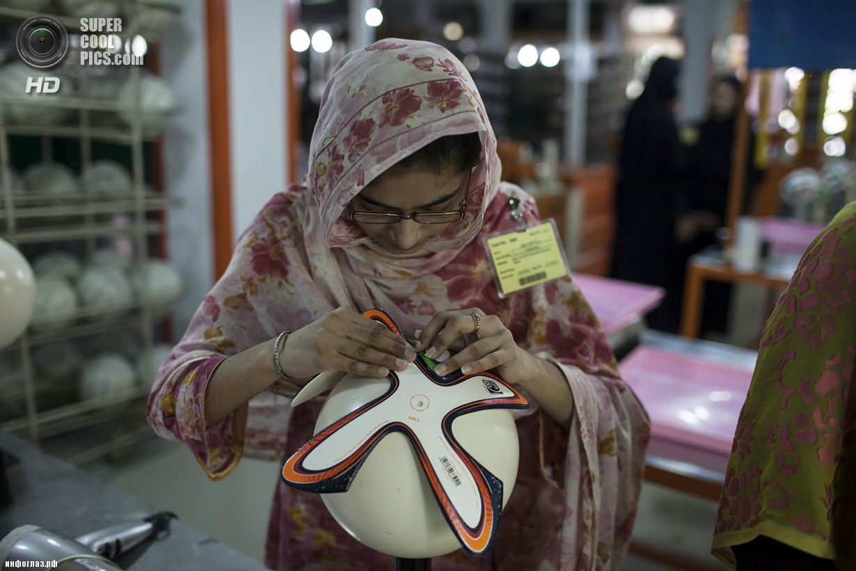 Пакистан. Сиялкот, Пенджаб. 16 мая. Работница фабрики оклеивает мяч фигурными панелями. (REUTERS/Sara Farid)