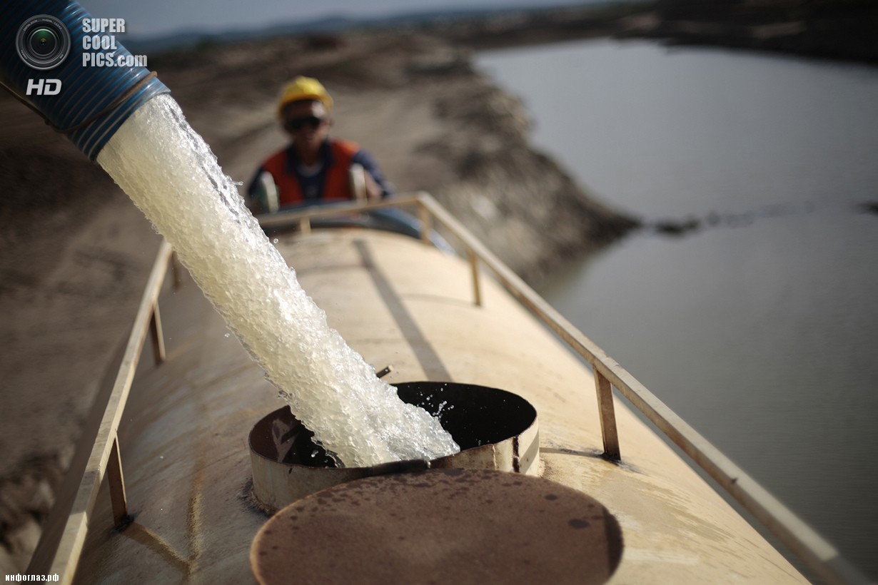 Бразилия. Маурити, Сеара. 28 января. Рабочие наполняют контейнер грузовика водой из канала. (REUTERS/Ueslei Marcelino)
