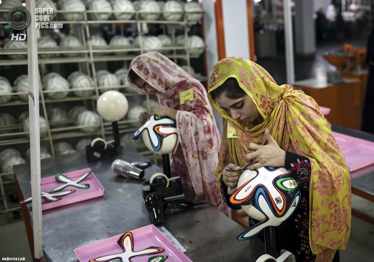 Пакистан. Сиялкот, Пенджаб. 16 мая. Работницы фабрики оклеивают мячи фигурными панелями. (REUTERS/Sara Farid)