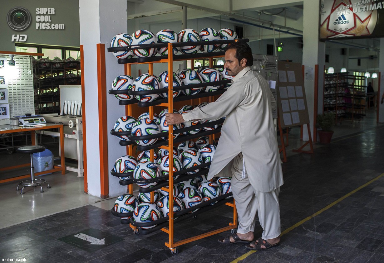 Пакистан. Сиялкот, Пенджаб. 16 мая. Работник фабрики увозит готовые мячи из цеха. (REUTERS/Sara Farid)