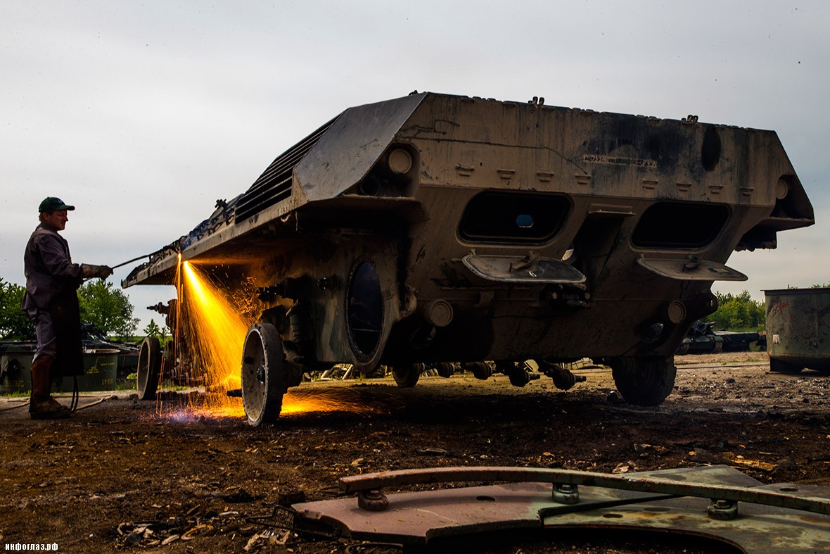 A worker cuts the body of a decommissioned armoured vehicle in the compound of the Koch Battle Tank Dismantling firm